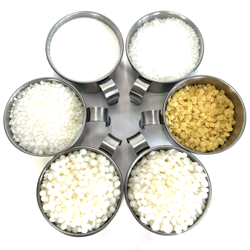 Cires végétales et minérales triées en pots pour comparaison visuelle