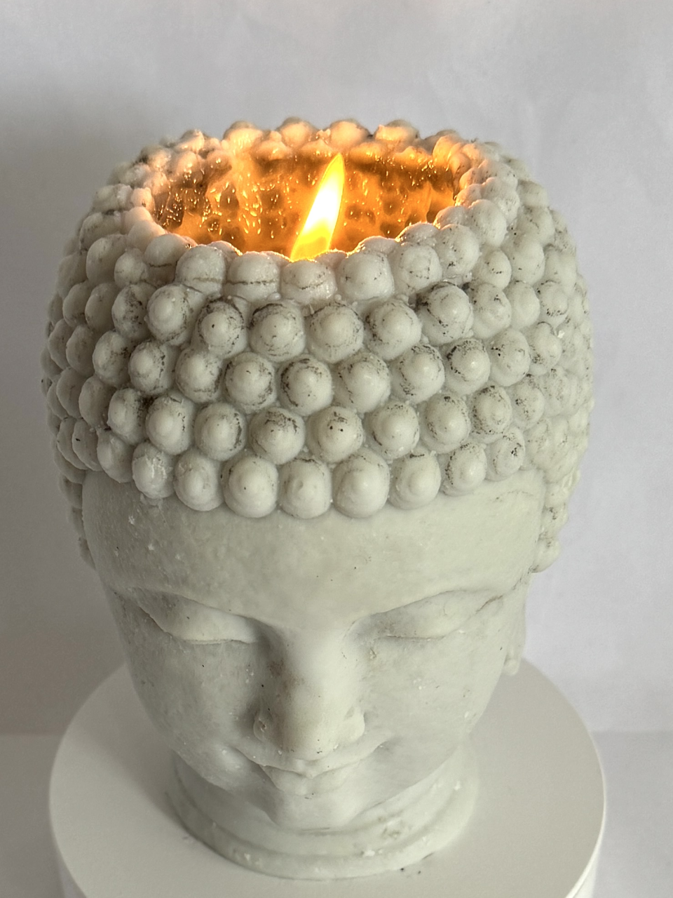 Bougie artisanale en forme de tête de Bouddha allumée – cire paraffine-stéarine, flamme centrale
