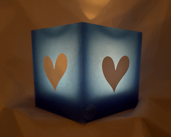 Photophore bleu à cœurs blancs – Collection boo-j-11 Photophore bleu en cire minérale, cube d’environ 12 cm de côté, orné de deux cœurs blancs. Création artisanale boo-j, laissant passer la lumière avec douceur.