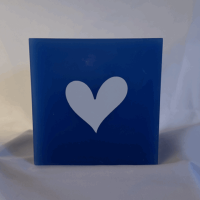 Photophore bleu à cœurs blancs – Collection boo-j-3 Photophore bleu en cire minérale, cube d’environ 12 cm de côté, orné de deux cœurs blancs. Création artisanale boo-j, laissant passer la lumière avec douceur.