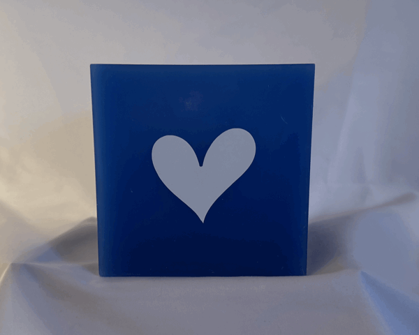 Photophore bleu à cœurs blancs – Collection boo-j-3 Photophore bleu en cire minérale, cube d’environ 12 cm de côté, orné de deux cœurs blancs. Création artisanale boo-j, laissant passer la lumière avec douceur.