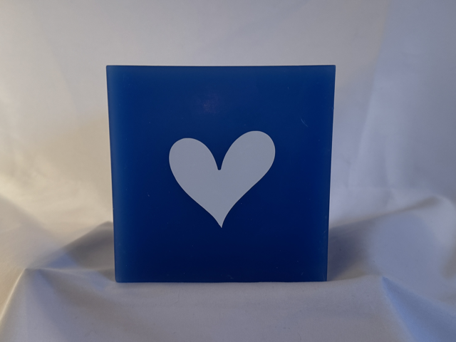 Photophore bleu à cœurs blancs – Collection boo-j-3 Photophore bleu en cire minérale, cube d’environ 12 cm de côté, orné de deux cœurs blancs. Création artisanale boo-j, laissant passer la lumière avec douceur.