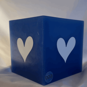 Photophore bleu en cire minérale, cube d’environ 12 cm de côté, orné de deux cœurs blancs. Création artisanale boo-j, laissant passer la lumière avec douceur.
