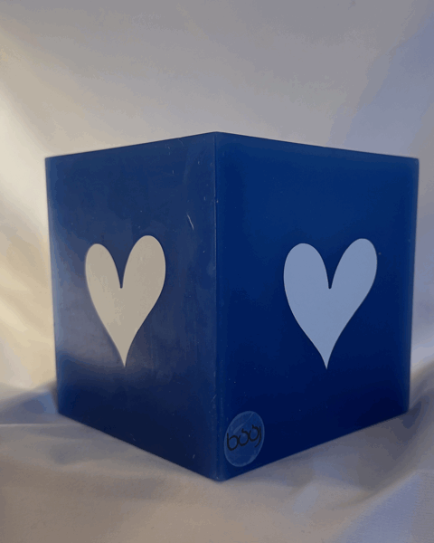 Photophore bleu à cœurs blancs – Collection boo-j Photophore bleu en cire minérale, cube d’environ 12 cm de côté, orné de deux cœurs blancs. Création artisanale boo-j, laissant passer la lumière avec douceur.