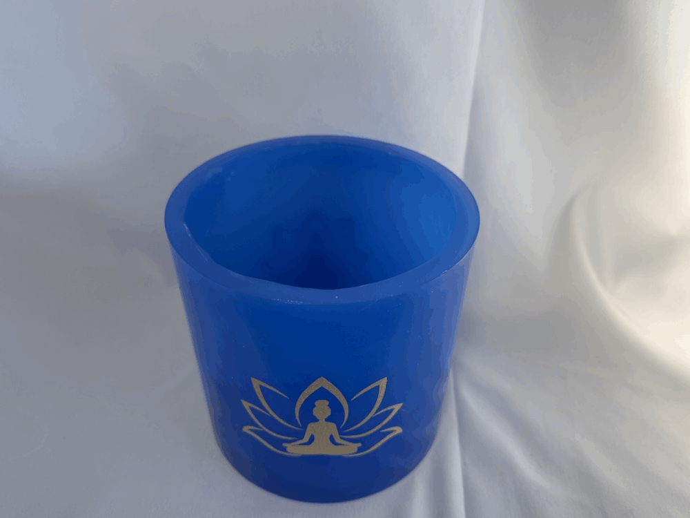 Photophore bleu lotus – femme méditant Photophore bleu en cire artisanale, diamètre 12 cm, décoré de deux motifs lotus dorés avec silhouette de femme méditant.