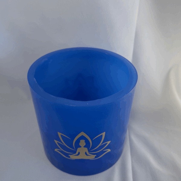 Photophore bleu lotus – femme méditant Photophore bleu en cire artisanale, diamètre 12 cm, décoré de deux motifs lotus dorés avec silhouette de femme méditant.