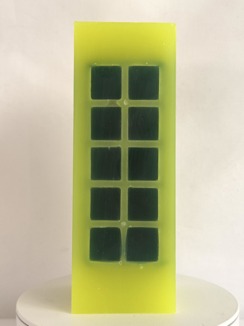 Bougie jaune citron fluo avec incrustations vert foncé