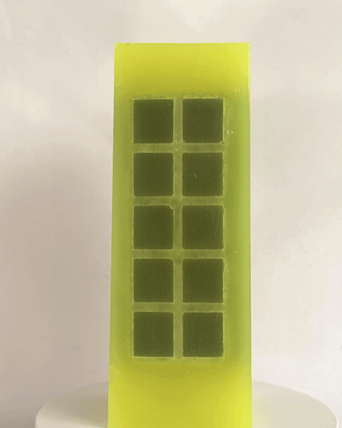 Bougie jaune citron fluo avec incrustations vert foncé