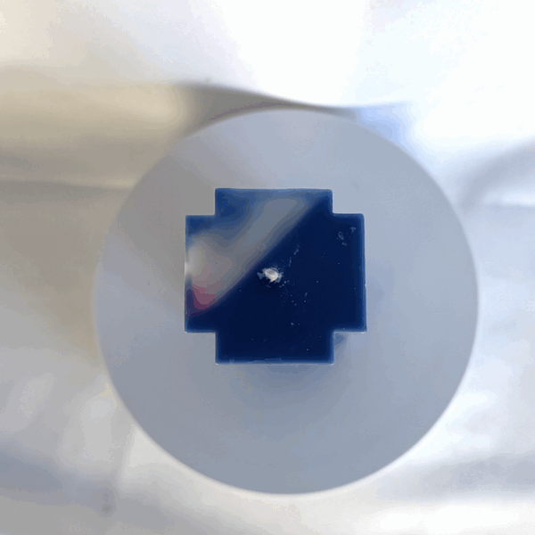 Bougie bleue en forme de croix, avec inclusion rose fluo et blanc