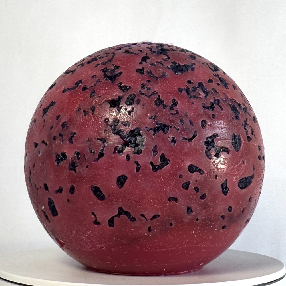 Mercury – sphère volcanique 10 cm – cire minérale rouge et violet Sphère de 10 cm rouge fluo avec éclats violets, effet brûlé, série Mercury