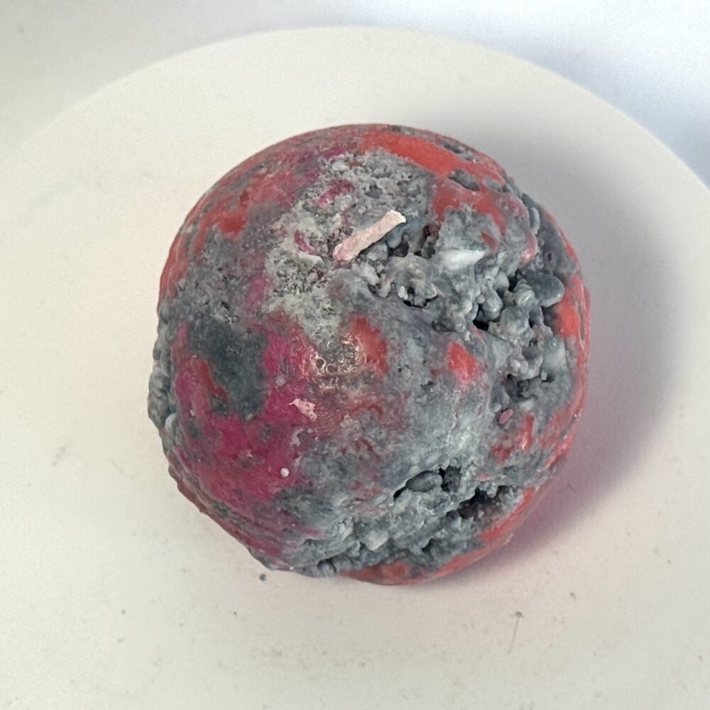 Petite sphère Mercury en cire minérale rouge, avec inclusions grises et forme irrégulière