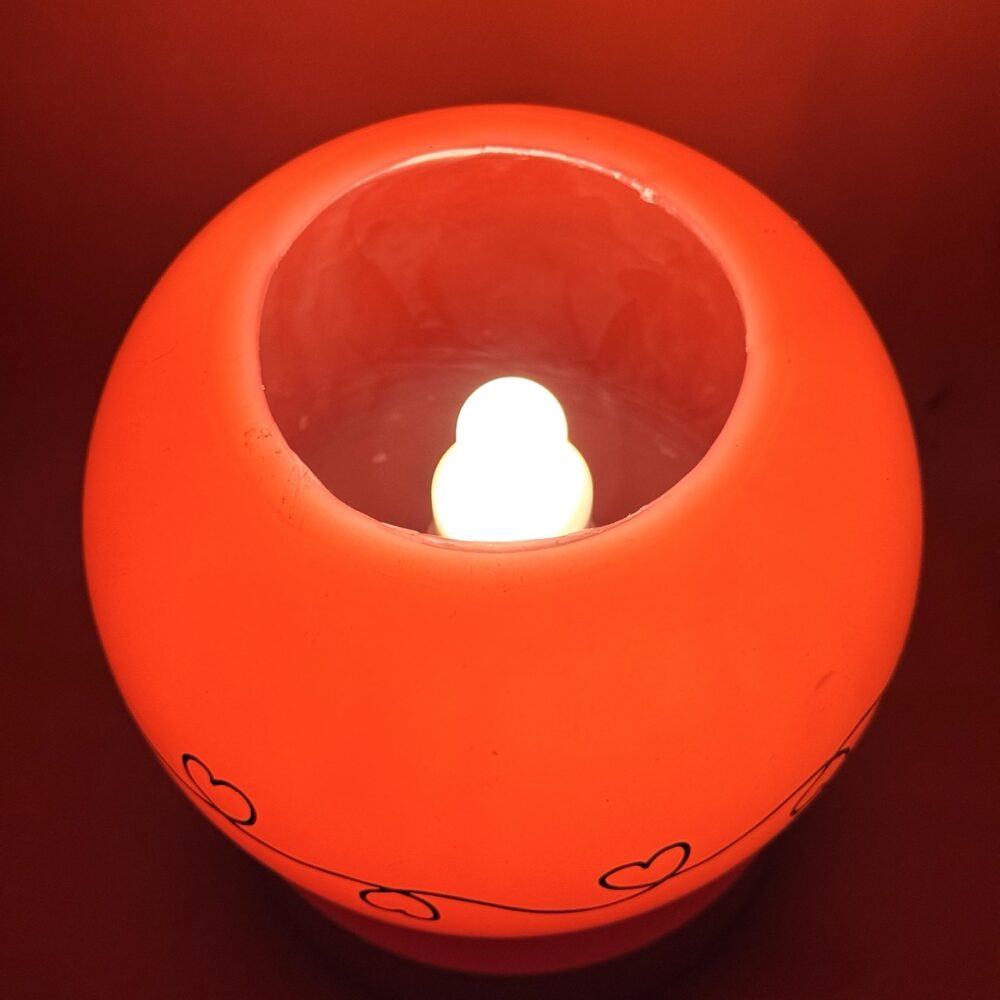 Photophore sphérique rouge à cœurs – cire minérale – 14 cm Photophore rouge en cire minérale avec motif de cœurs noirs, diamètre 14 cm