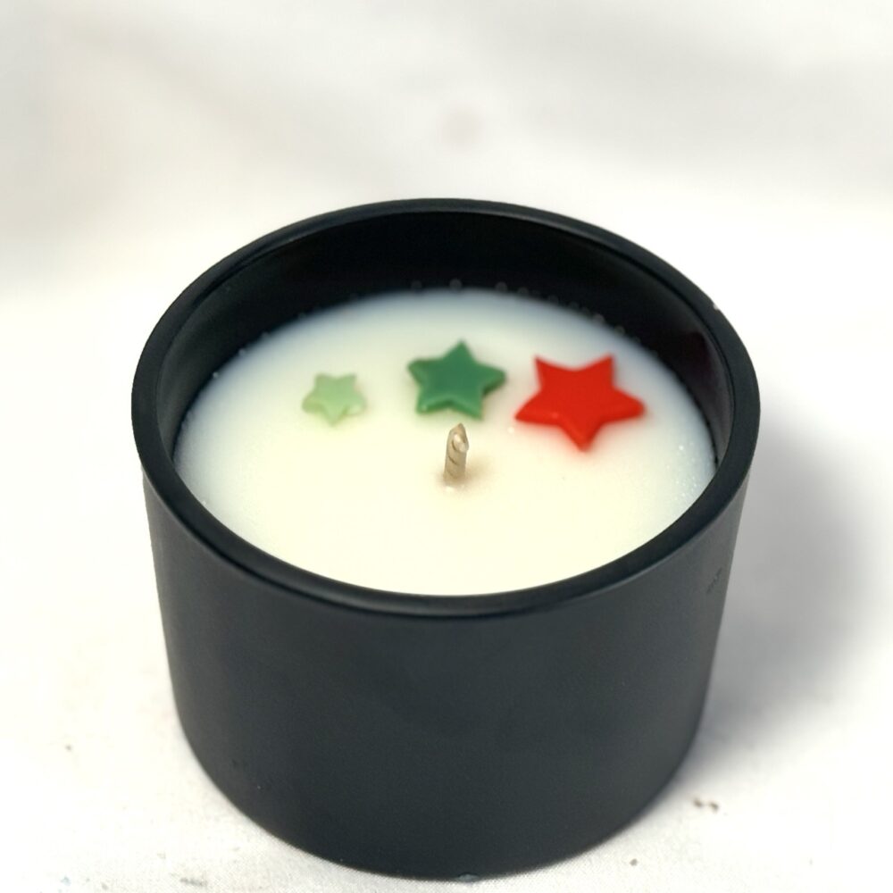 Bougie parfumée CONIFÊTES dans son pot, avec étoiles colorées visibles en surface avant fermeture