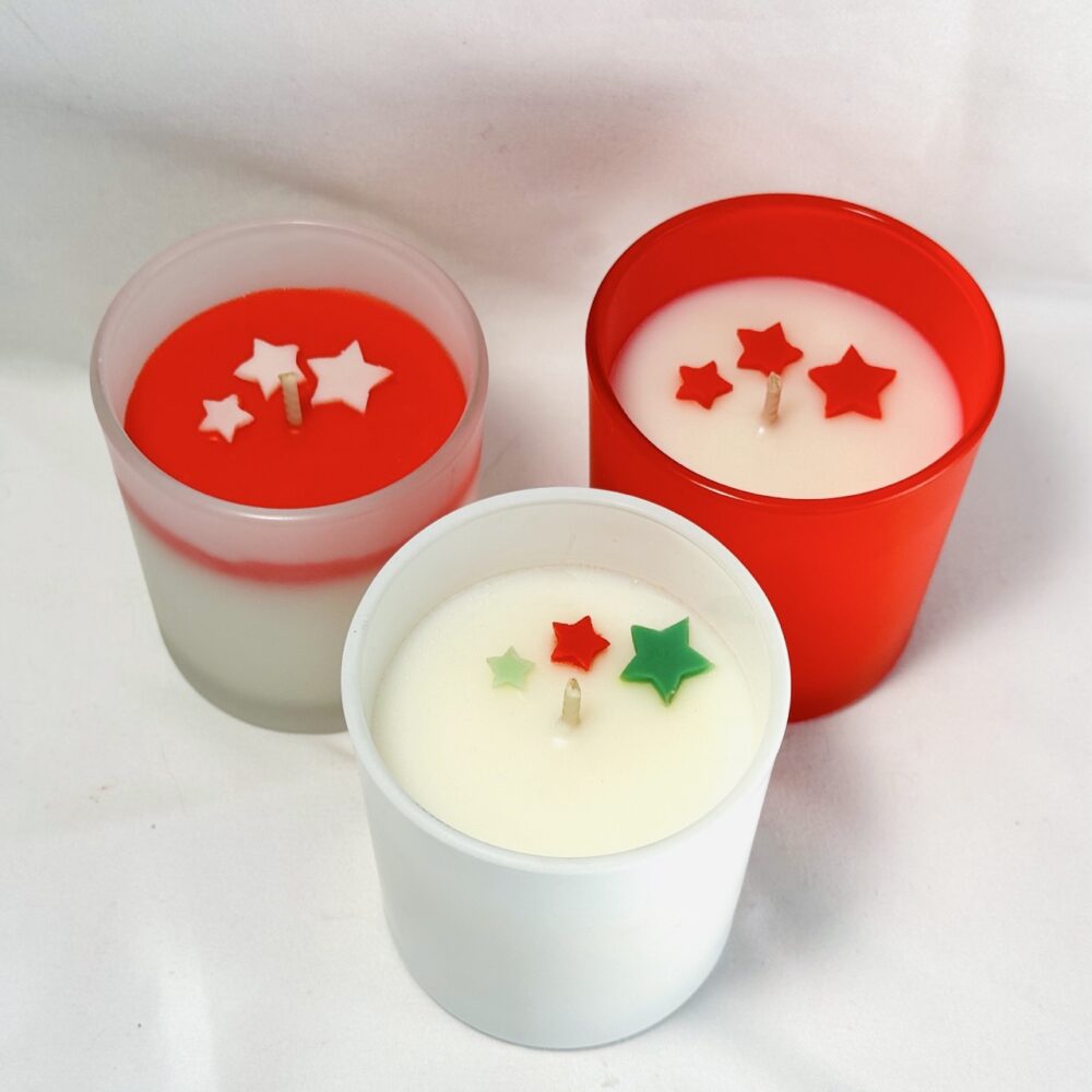 Bougie parfumée CONIFÊTES dans son pot, avec étoiles colorées visibles en surface avant fermeture