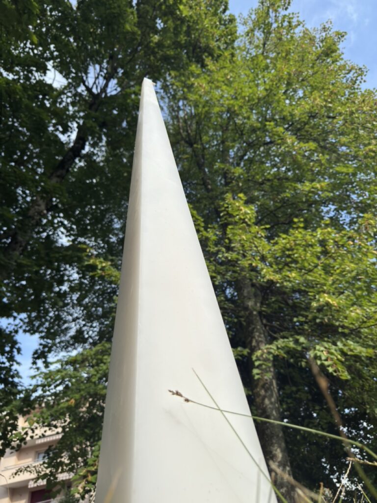 Grande bougie pyramidale Luxor en cire minérale et végétale, 125 cm de hauteur pour 10 kg, photographie en extérieur sur herbe.