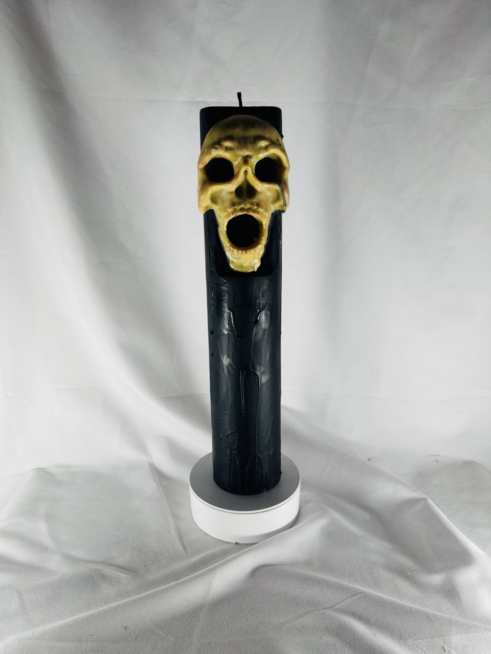 Bougie artisanale Halloween en forme de pilier noir avec crâne jaune sculpté – boo-j édition spectrale