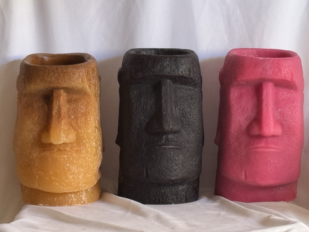 Trois photophores Moaï en cire recyclée — beige, noir et rose — créations sculpturales artisanales boo-j