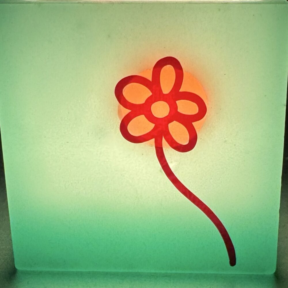 Photophore cube vert à fleurs rouges – cire minérale translucide Photophore cube vert translucide en cire minérale, décoré de fleurs rouges lumineuses, création artisanale boo-j.