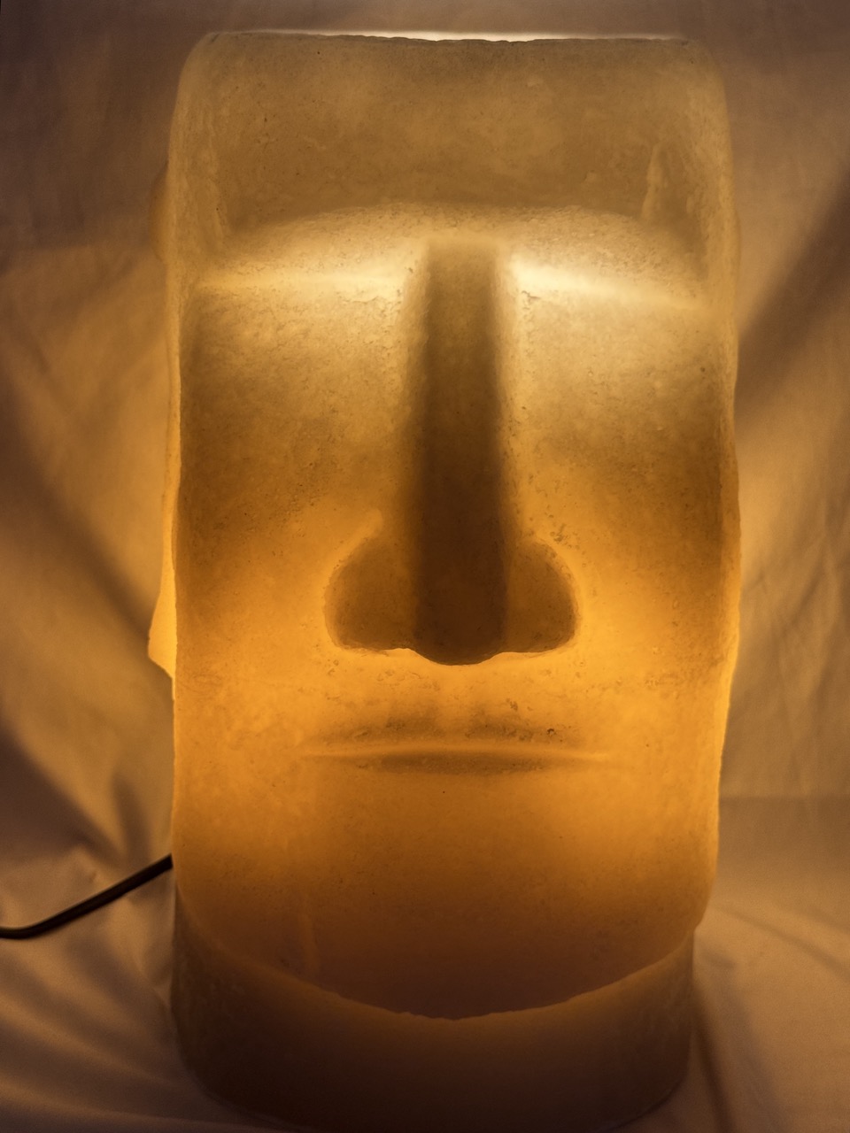 Photophore Moaï en cire recyclée éclairé de l’intérieur, vue de profil.