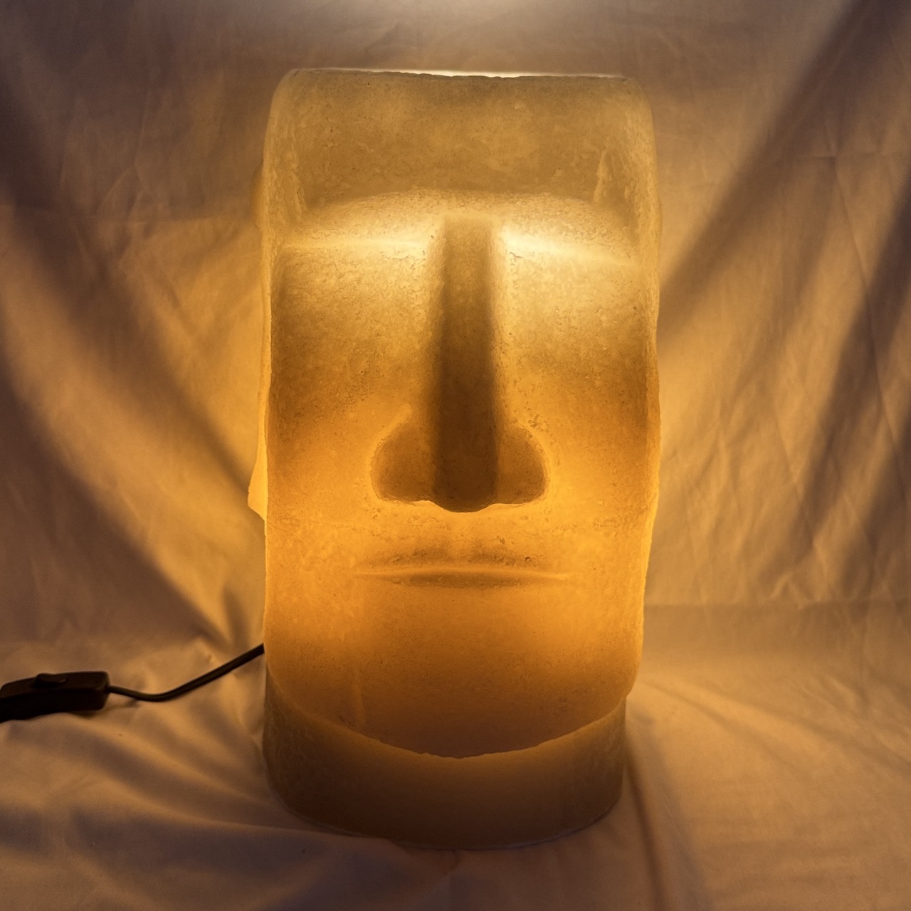 Photophore Moaï en cire recyclée éclairé de l’intérieur, vue de profil.