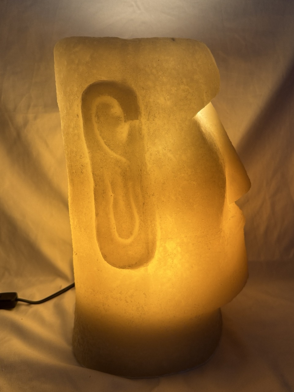 Photophore Moaï en cire recyclée éclairé de l’intérieur, vue de profil.