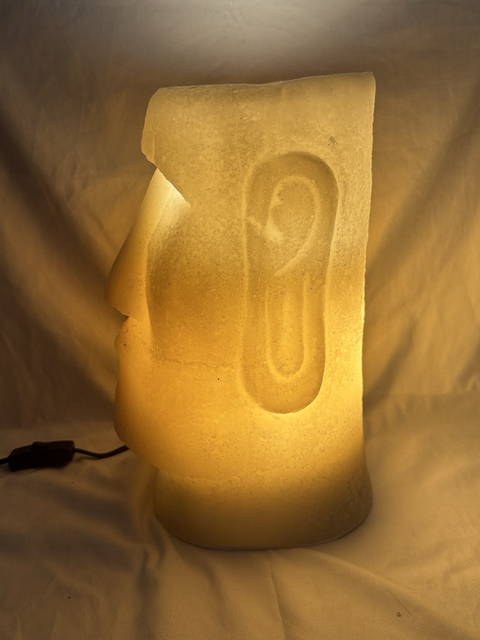 Photophore Moaï en cire recyclée éclairé de l’intérieur, vue de profil.