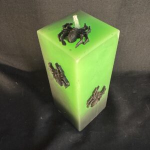 Vidéo d’une bougie pilier Halloween verte en cire minérale et végétale, décorée d’araignées en cire d’abeille noire — création artisanale suisse boo-j, édition spectrale