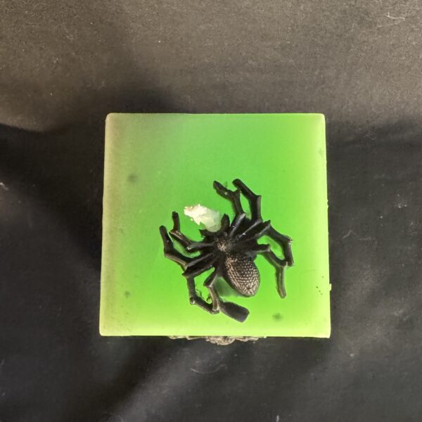 Bougie pilier 6 × 16 cm en cire minérale et végétale verte, décorée d’araignées en cire d’abeille noire — fabrication artisanale suisse | boo-j édition spectrale Bougie pilier Halloween verte en cire minérale et végétale, décorée d’araignées en cire d’abeille noire — création artisanale suisse boo-j, édition spectrale