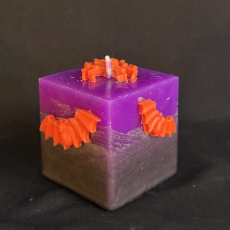 Bougie cube 5 × 5 × 5 cm violette — araignée et chauves-souris orange en cire d’abeille | boo-j édition spectrale Bougie cube violette en cire minérale et végétale, décorée d’une araignée et de deux chauves-souris en cire d’abeille orange vif — création artisanale suisse boo-j, édition spectrale