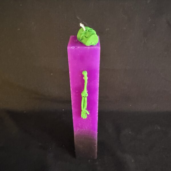 Bougie pilier Halloween violette en cire minérale et végétale, décorée d’un crâne et d’os en cire d’abeille vert fluo — création artisanale suisse boo-j, édition spectrale