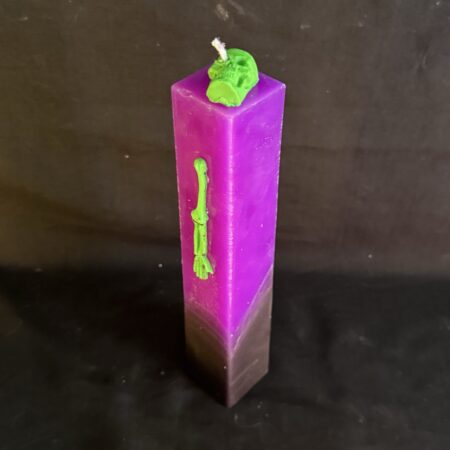 Bougie pilier 3,8 × 21 cm violette — crâne et os verts en cire d’abeille | boo-j édition spectrale Bougie pilier Halloween violette en cire minérale et végétale, décorée d’un crâne et d’os en cire d’abeille vert fluo — création artisanale suisse boo-j, édition spectrale