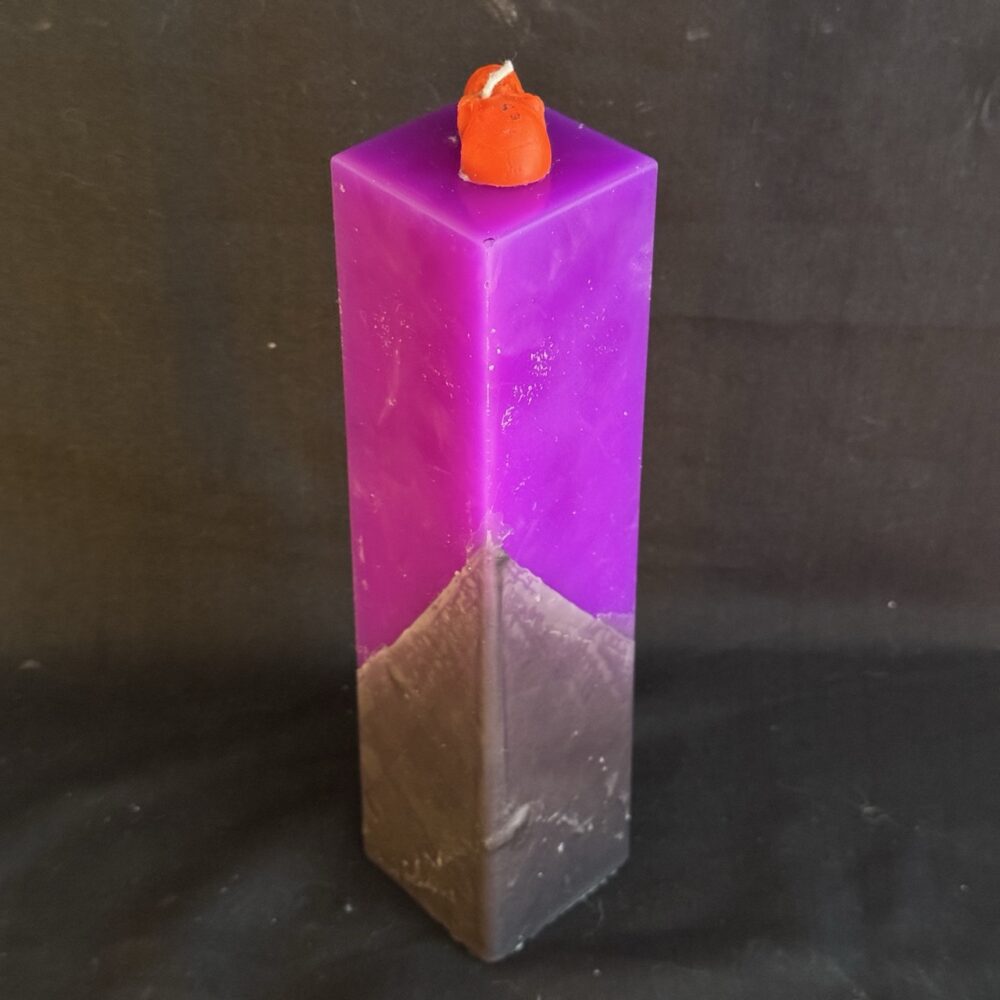 Bougie pilier 5 × 21 cm violette — crâne et os en cire d’abeille orange | boo-j édition spectrale Bougie pilier Halloween violette en cire minérale et végétale, décorée d’un crâne et d’os en cire d’abeille orange vif — création artisanale suisse boo-j, édition spectrale