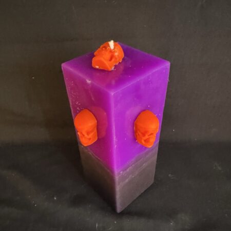 Bougie pilier 6 × 16 cm violette — trois crânes orange en cire d’abeille | boo-j édition spectrale Bougie pilier Halloween violette en cire minérale et végétale, décorée de trois crânes en cire d’abeille orange vif — création artisanale suisse boo-j, édition spectrale