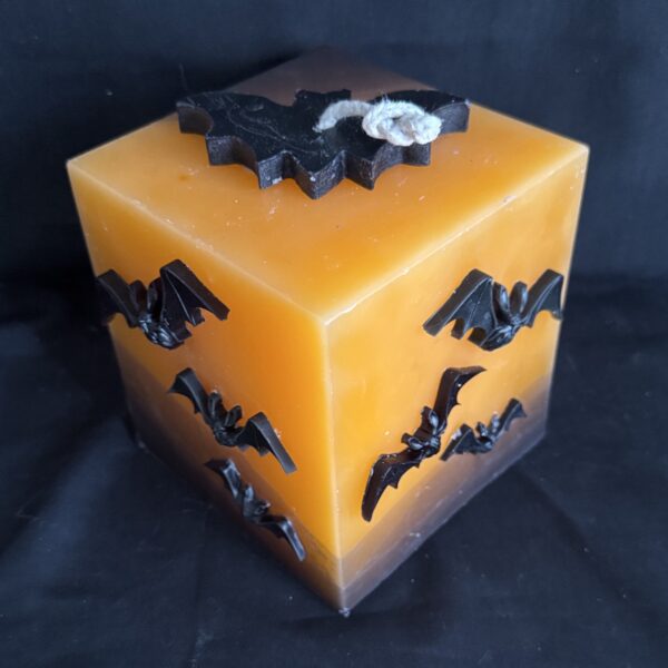 Bougie cubique Halloween de 12 cm, plus de 1,5 kg, en cire minérale et végétale orange avec chauves-souris en cire d’abeille noire — création artisanale suisse boo-j, édition spectrale