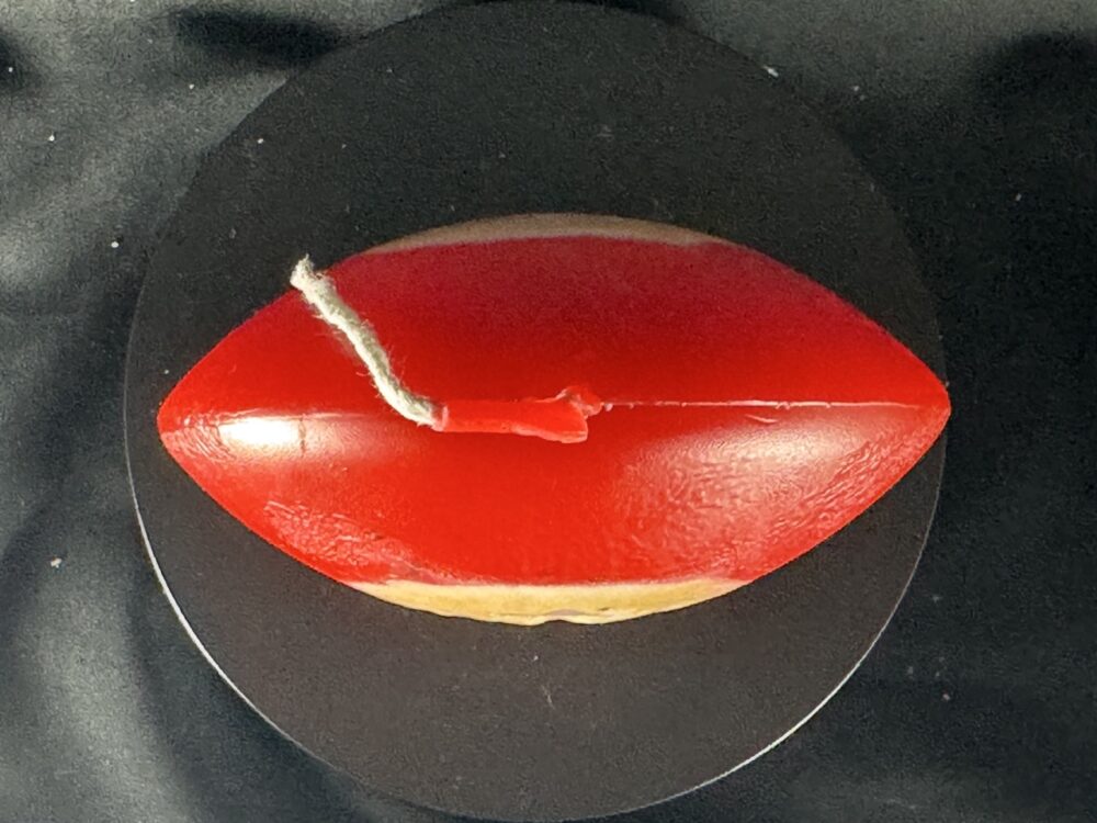 Bougie artisanale rouge et dorée de 10 cm avec motif central de flocon blanc, coulée à la main en cire minérale et végétale. Création boo-j réalisée dans le canton de Vaud.