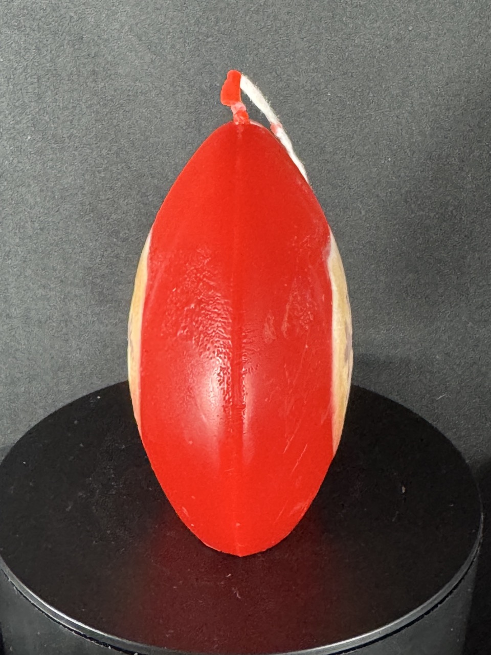 Bougie artisanale rouge et dorée de 10 cm avec motif central de flocon blanc, coulée à la main en cire minérale et végétale. Création boo-j réalisée dans le canton de Vaud.