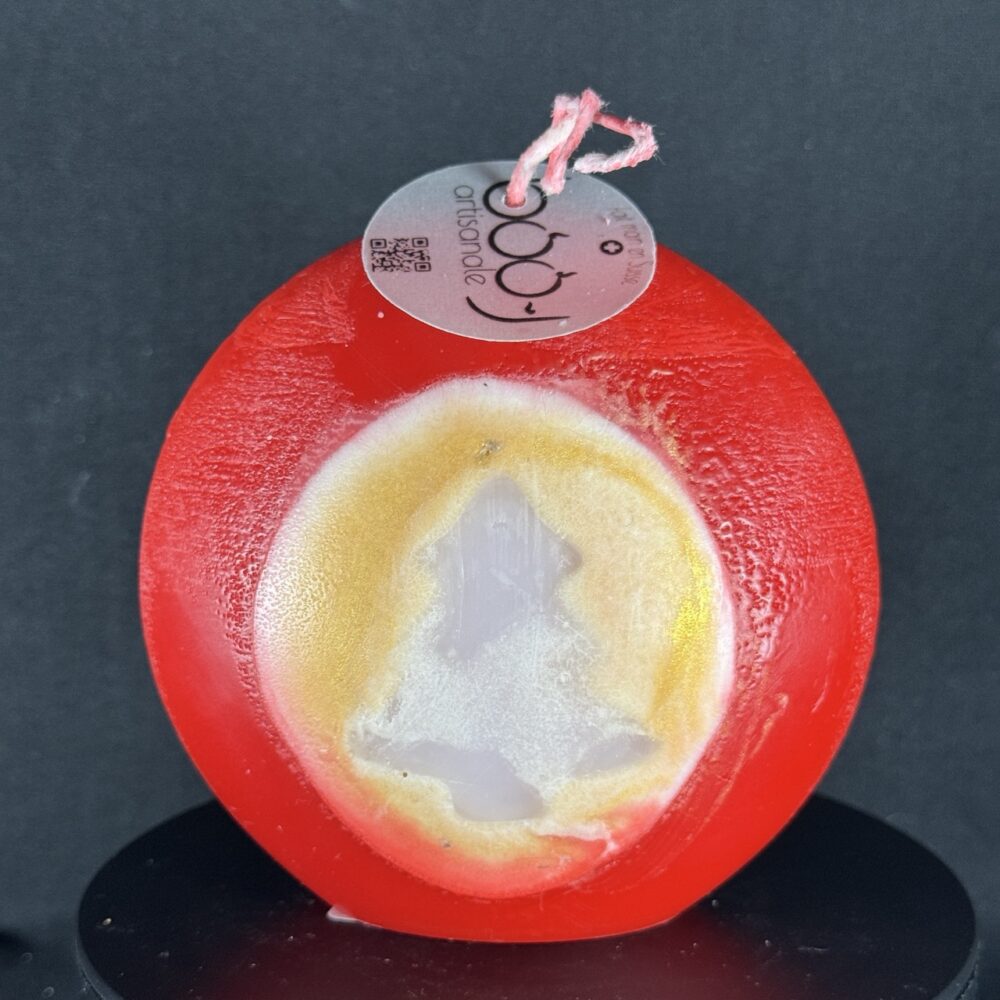 Bougie artisanale rouge et dorée de 10 cm avec motif central de sapin blanc, coulée à la main en cire minérale et végétale. Création boo-j, fabriquée dans le canton de Vaud.