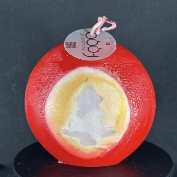 Bougie artisanale rouge et dorée de 10 cm avec motif central de sapin blanc, coulée à la main en cire minérale et végétale. Création boo-j, fabriquée dans le canton de Vaud.