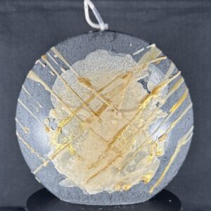 Bougie artisanale en forme de disque, finition gris minéral avec coulures et dorures manuelles. Création boo-j en cire végétale, réalisée à la main dans le canton de Vaud.