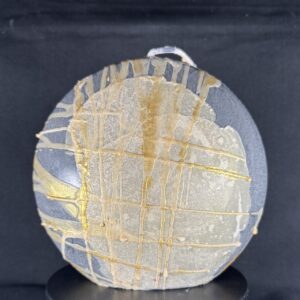 Bougie disque gris et doré – boo-j Bougie artisanale en forme de disque, finition gris minéral avec coulures et dorures manuelles. Création boo-j en cire végétale et minérale, réalisée à la main dans le canton de Vaud.