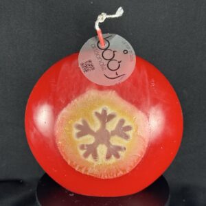 Bougie artisanale rouge et dorée avec motif central de flocon blanc, coulée à la main en cire minérale et végétale. Création boo-j, fabriquée dans le canton de Vaud.