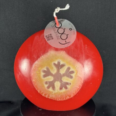 Bougie artisanale rouge et dorée avec motif central de flocon blanc, coulée à la main en cire minérale et végétale. Création boo-j, fabriquée dans le canton de Vaud.