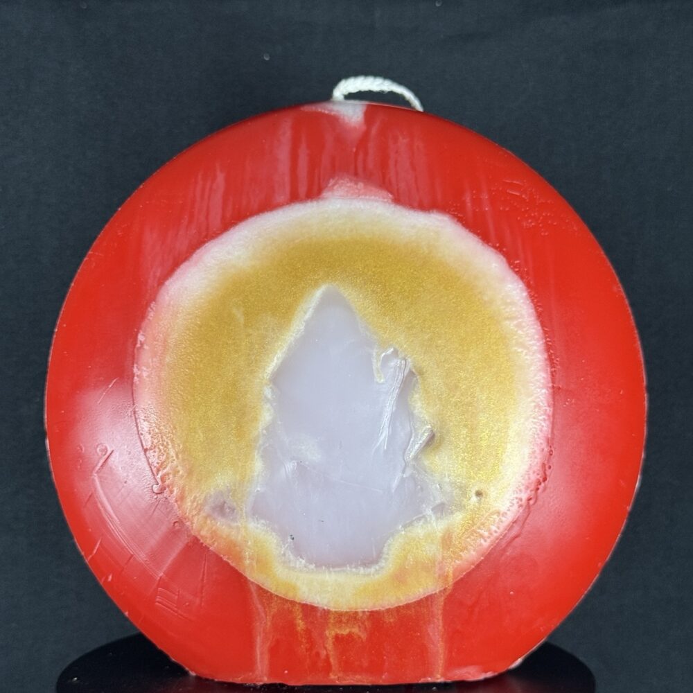 Bougie artisanale rouge et dorée avec motif central de sapin blanc, coulée à la main en cire minérale et végétale. Création boo-j, réalisée dans le canton de Vaud.