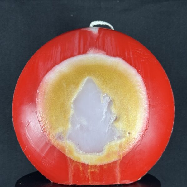 Bougie artisanale rouge et dorée avec motif central de sapin blanc, coulée à la main en cire minérale et végétale. Création boo-j, réalisée dans le canton de Vaud.