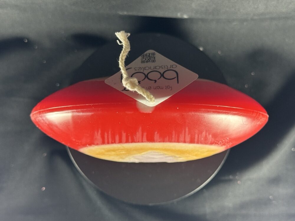 Bougie artisanale rouge et dorée avec motif central de sapin blanc, coulée à la main en cire minérale et végétale. Création boo-j, réalisée dans le canton de Vaud.