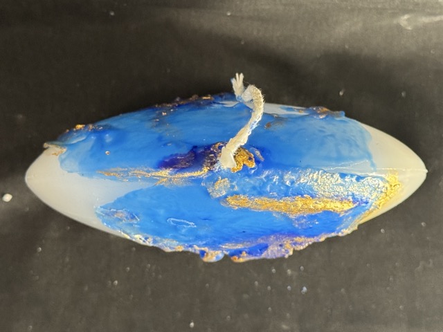 Bougie disque 14 cm de la collection Nuit Étoilée, en cire minérale et végétale blanche, avec finition bleu outremer et dorures à la main. Création artisanale boo-j, environ 520 g, combustion ± 50 h.