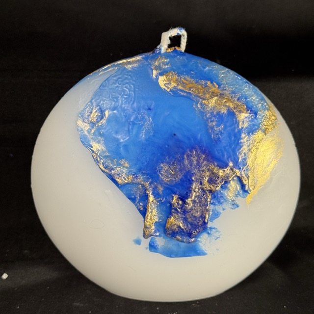 Bougie disque 14 cm de la collection Nuit Étoilée, en cire minérale et végétale blanche, avec finition bleu outremer et dorures à la main. Création artisanale boo-j, environ 520 g, combustion ± 50 h.