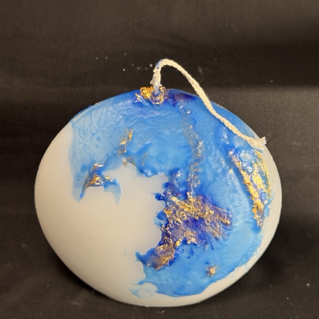 Bougie disque 14 cm de la collection Nuit Étoilée, en cire minérale et végétale blanche, avec finition bleu outremer et dorures à la main. Création artisanale boo-j, environ 520 g, combustion ± 50 h.