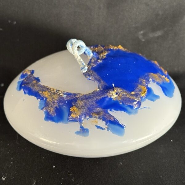 Bougie soucoupe 12,5 × 6 cm de la collection Nuit Étoilée, en cire minérale et végétale blanche avec finitions bleu outremer et dorures appliquées à la main. Création artisanale boo-j, env. 370 g, combustion ± 15 h.
