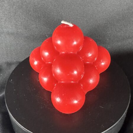 Bougie artisanale rouge en forme de pyramide de bulles, coulée à la main en cire minérale et végétale. Création boo-j, au design ludique et festif.
